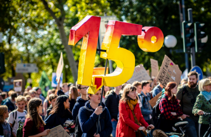 Crowd with 1.5% banner for net zero target