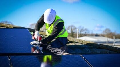 A solar installer working on a rooftop installation