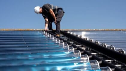 An installer pictured on the roof of Westminster University installing the Naked Energy VirtuHot solar thermal tubes.